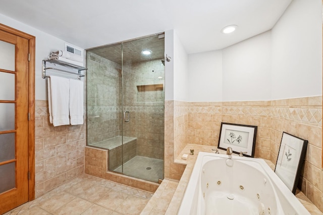 bathroom with a shower stall, a whirlpool tub, recessed lighting, tile patterned floors, and tile walls