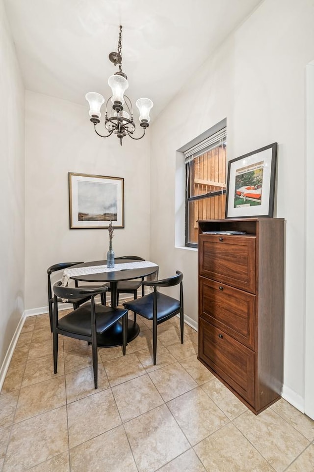 dining area with light tile patterned floors, baseboards, and a chandelier