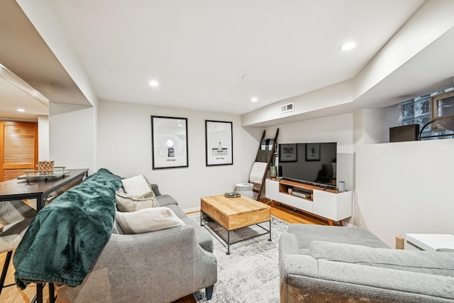 living area with recessed lighting, visible vents, baseboards, and wood finished floors