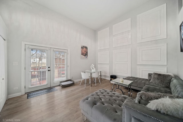 living room with french doors, baseboards, and wood finished floors