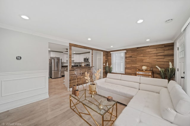 living area with recessed lighting, light wood-type flooring, and ornamental molding