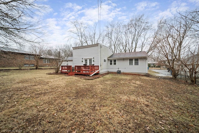 back of property featuring a lawn and a wooden deck