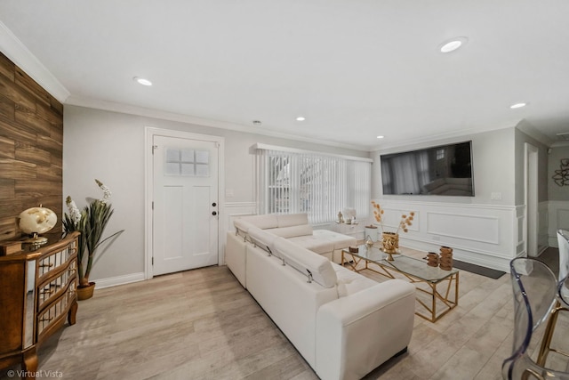 living area featuring a decorative wall, recessed lighting, light wood-type flooring, and ornamental molding