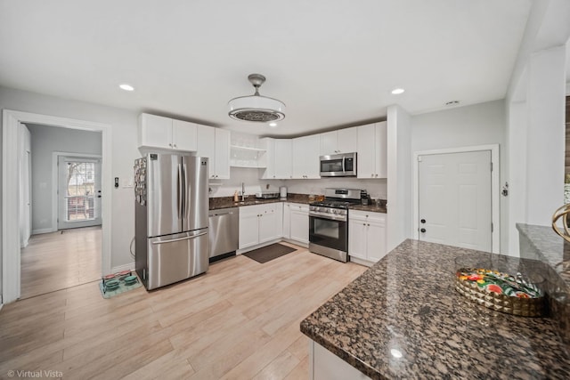 kitchen featuring white cabinets, light wood finished floors, appliances with stainless steel finishes, and a sink