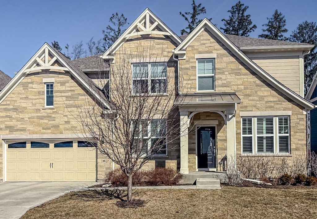 view of front of house with stone siding, roof with shingles, concrete driveway, and an attached garage