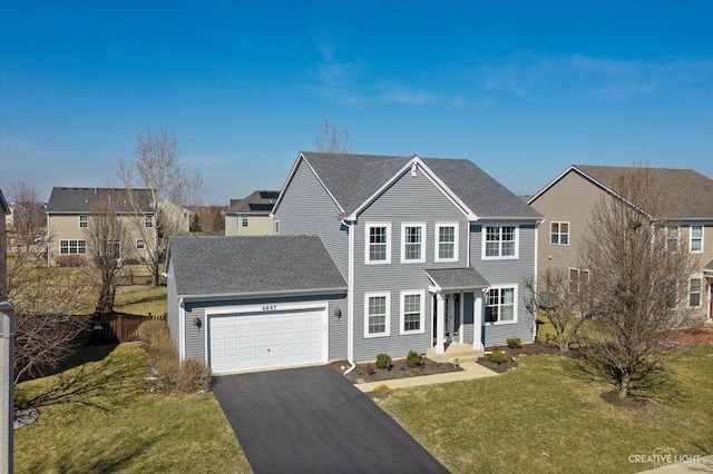 view of front facade featuring fence, a front yard, roof with shingles, a garage, and driveway