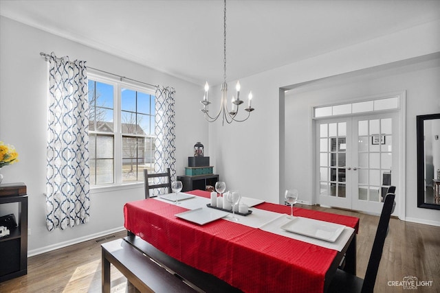 dining room with wood finished floors, french doors, baseboards, and a chandelier