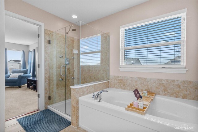 ensuite bathroom featuring a garden tub, ensuite bath, a shower stall, and tile patterned flooring