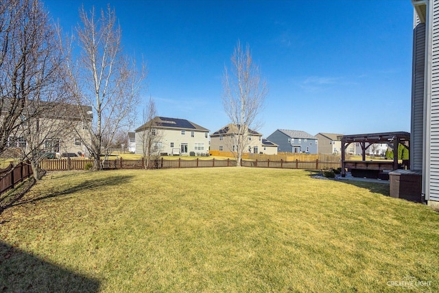 view of yard featuring a residential view, a fenced backyard, and a pergola