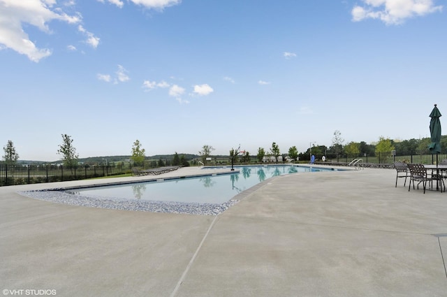 pool with a patio and fence