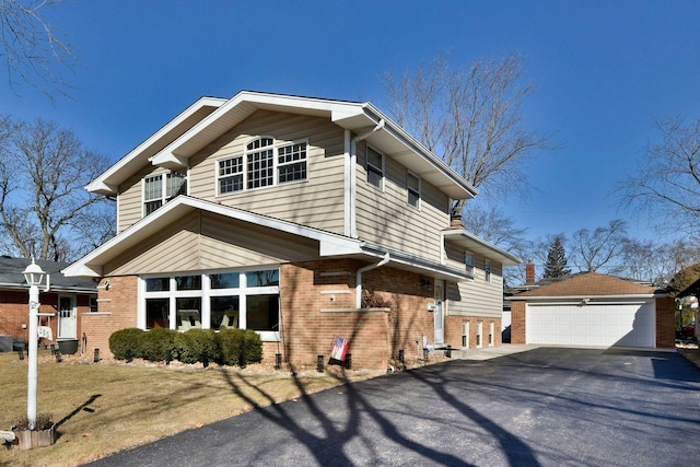 view of front of house with an outbuilding, a garage, and brick siding