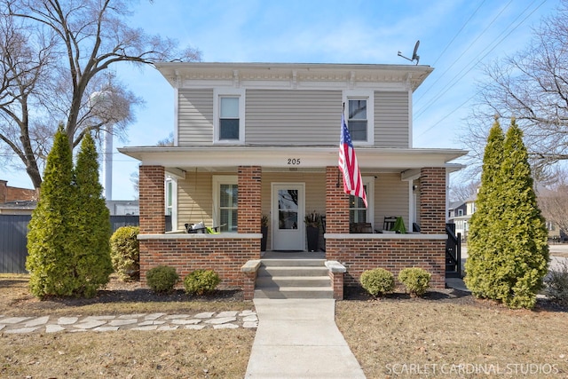 italianate house featuring brick siding and covered porch