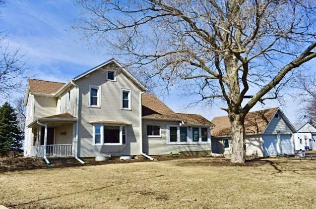 back of house with a porch and a yard