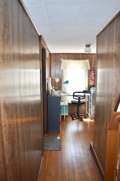 hallway featuring wooden walls and hardwood / wood-style floors