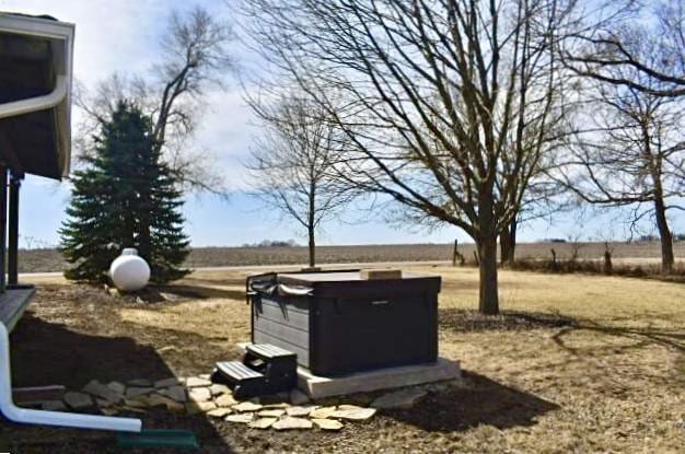 exterior space with a rural view and a hot tub