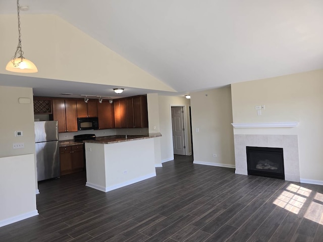 2401 Echelon Cir Unit C, Matteson, IL 60443 - kitchen featuring freestanding refrigerator, black microwave, a tiled fireplace, dark wood-style flooring, and lofted ceiling