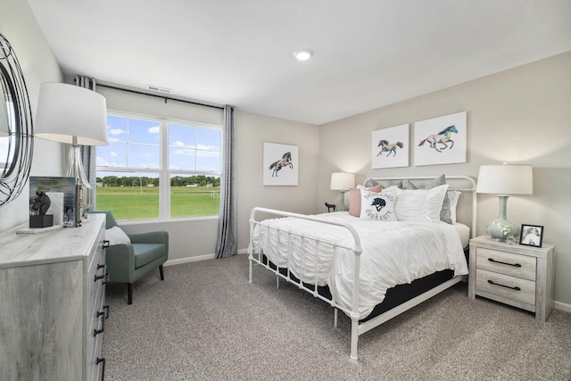 bedroom with baseboards, visible vents, and light carpet