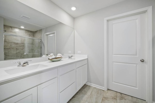 full bathroom with baseboards, visible vents, double vanity, a stall shower, and a sink