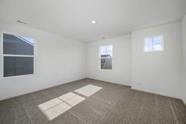 carpeted empty room with visible vents and baseboards