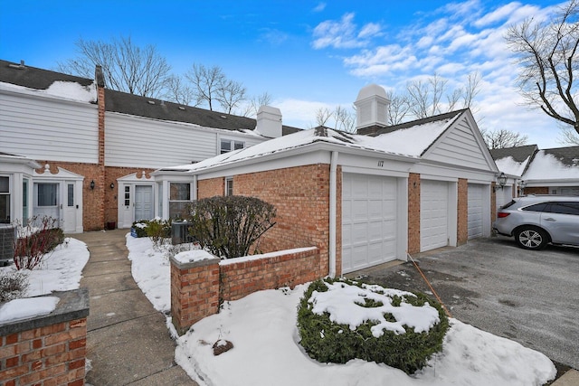 view of snowy exterior featuring brick siding