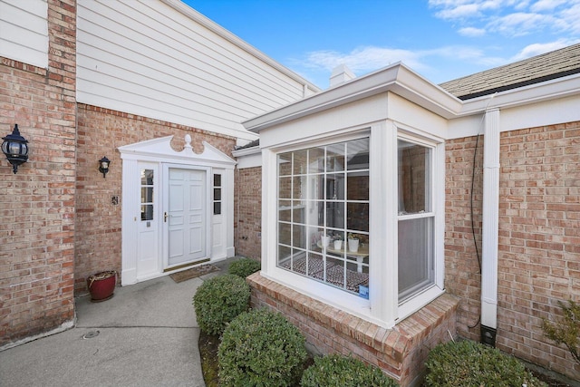 doorway to property with brick siding