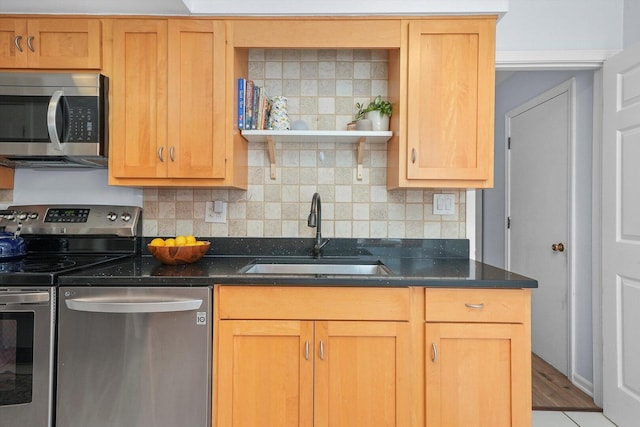 kitchen featuring dark stone countertops, open shelves, a sink, stainless steel appliances, and tasteful backsplash