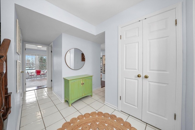 hallway featuring light tile patterned flooring and baseboards