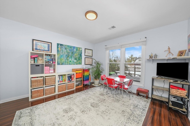 recreation room with visible vents, baseboards, and wood finished floors