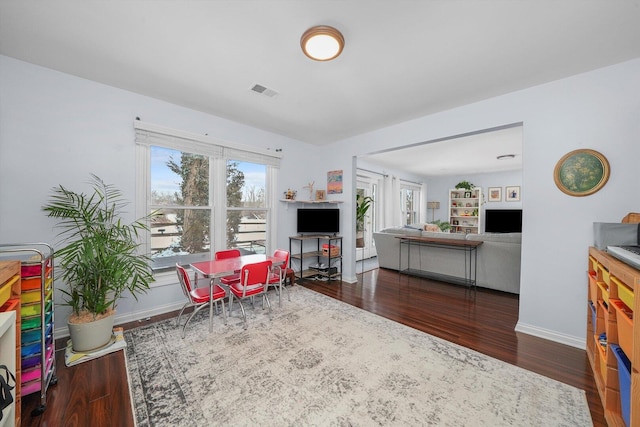 interior space with wood finished floors, visible vents, and baseboards