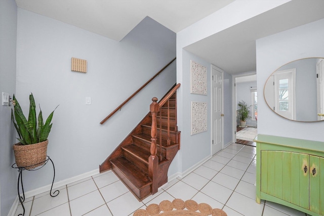 staircase with tile patterned floors and baseboards