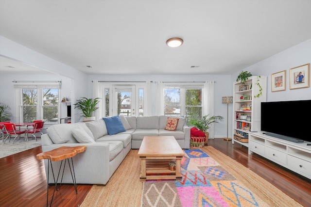 living room with plenty of natural light, visible vents, and wood finished floors