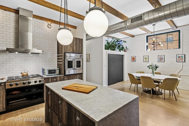 kitchen featuring visible vents, backsplash, wall chimney range hood, beamed ceiling, and appliances with stainless steel finishes