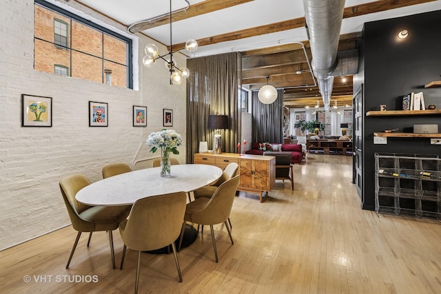 dining space with beamed ceiling, a notable chandelier, a high ceiling, and light wood finished floors