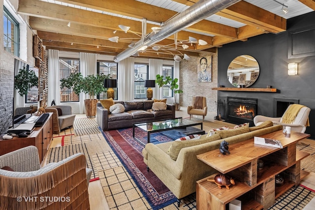 living area with beam ceiling and a lit fireplace