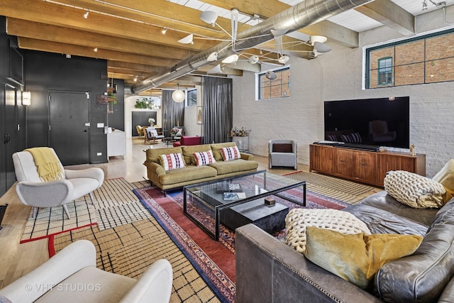 living room with beamed ceiling and wood finished floors