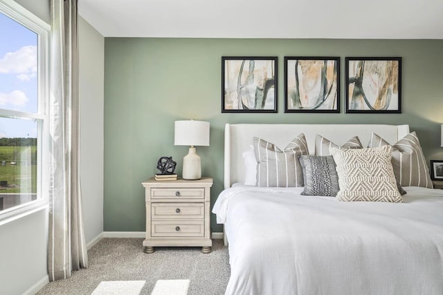 bedroom featuring baseboards and light carpet