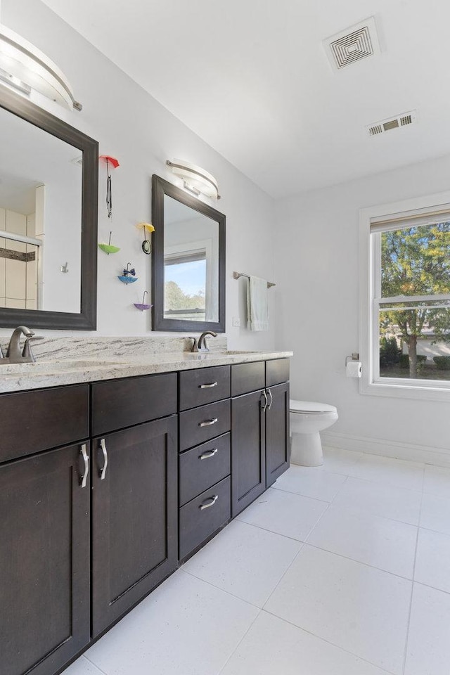 full bath featuring tile patterned floors, visible vents, toilet, and double vanity