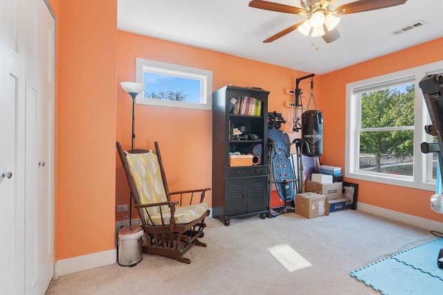 sitting room with a ceiling fan, carpet, visible vents, and baseboards