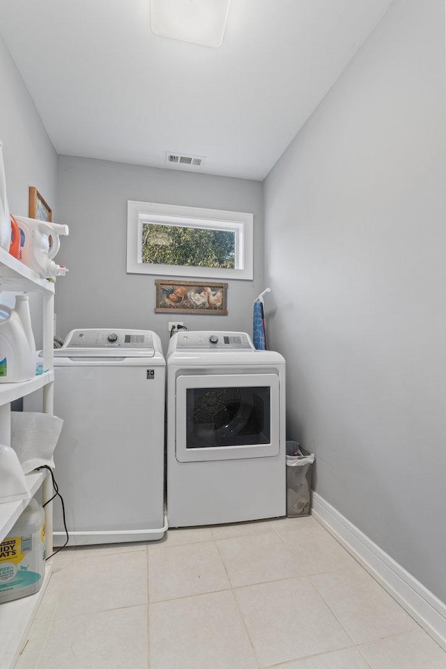 washroom with visible vents, separate washer and dryer, tile patterned flooring, baseboards, and laundry area