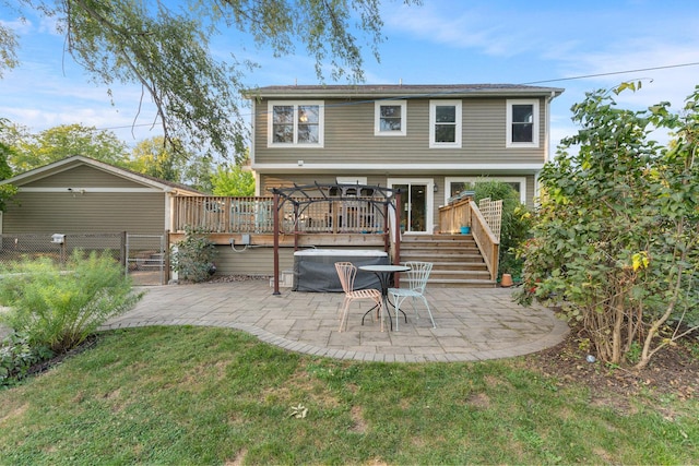 back of house with a gate, fence, a deck, a patio area, and a lawn