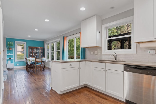 kitchen with a sink, stainless steel dishwasher, a peninsula, and hardwood / wood-style flooring