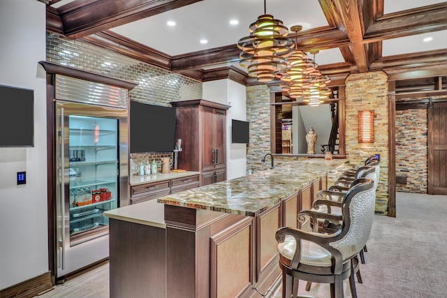 kitchen featuring beam ceiling, ornamental molding, coffered ceiling, and built in fridge