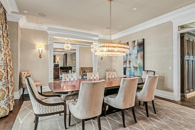 dining space featuring ornate columns, wood finished floors, baseboards, and ornamental molding