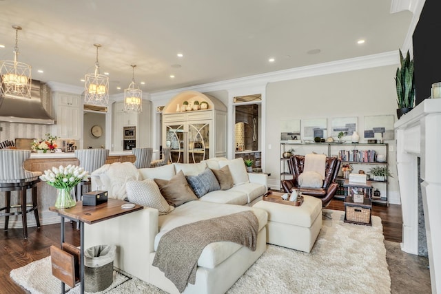 living area with recessed lighting, dark wood-type flooring, an inviting chandelier, and ornamental molding