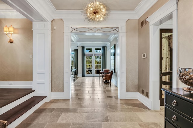 entrance foyer featuring visible vents, ornamental molding, stone finish flooring, french doors, and ornate columns