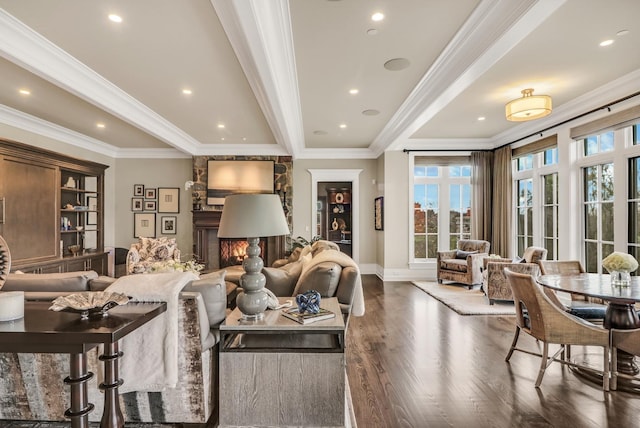 living room with a fireplace, crown molding, baseboards, and wood finished floors