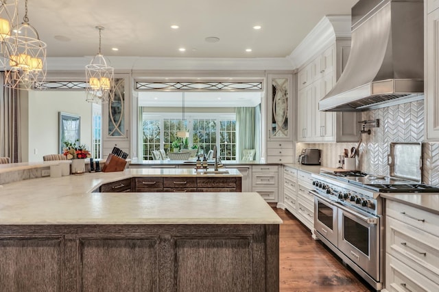 kitchen with range with two ovens, dark wood-style flooring, a sink, custom range hood, and tasteful backsplash