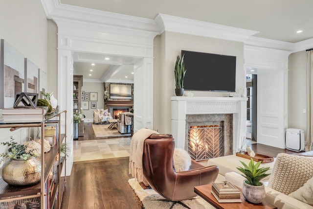 living room featuring crown molding, recessed lighting, dark wood-style flooring, and a warm lit fireplace