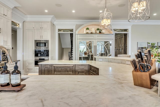 kitchen featuring a notable chandelier, pendant lighting, ornamental molding, light stone counters, and appliances with stainless steel finishes