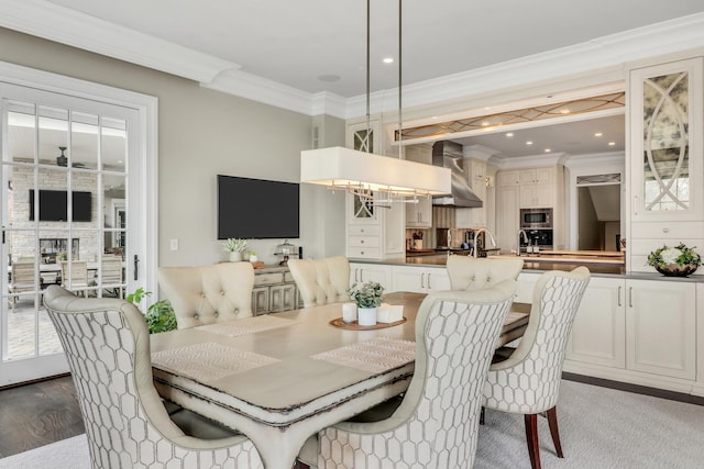 dining space with recessed lighting, wood finished floors, and ornamental molding